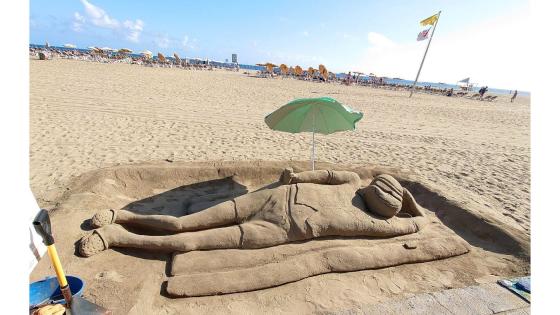 Sandskulptur under parsaoll på strand.